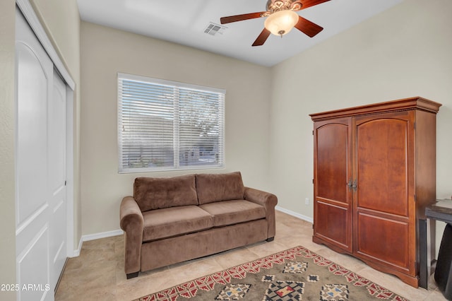 living area with baseboards, light tile patterned flooring, visible vents, and a ceiling fan