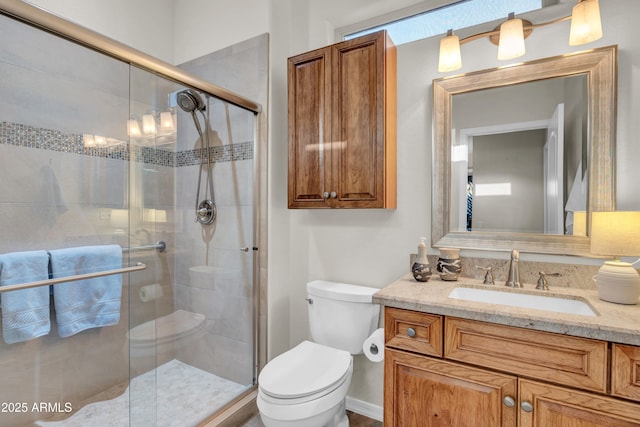 bathroom with vanity, a shower stall, and toilet