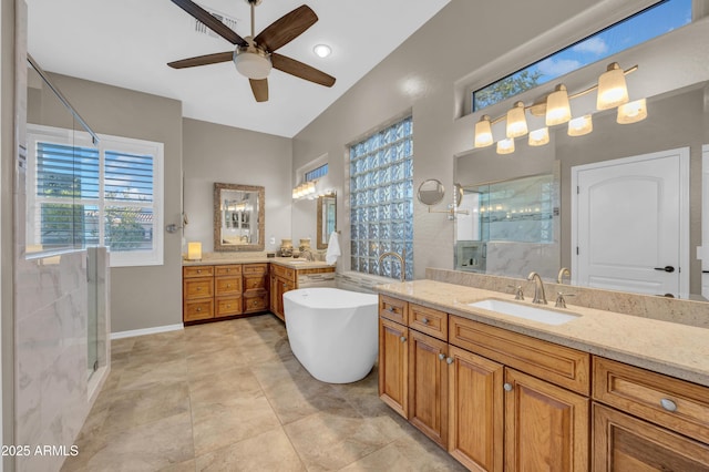 full bath featuring a stall shower, two vanities, and a sink