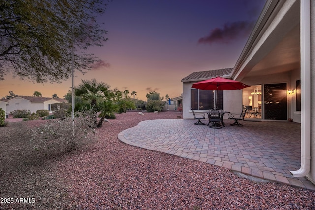 yard at dusk featuring a patio