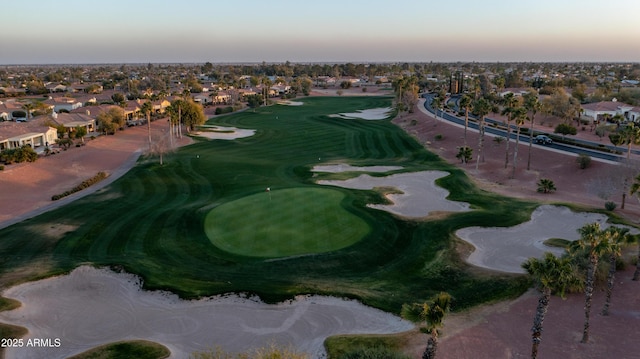 aerial view at dusk with a residential view and view of golf course