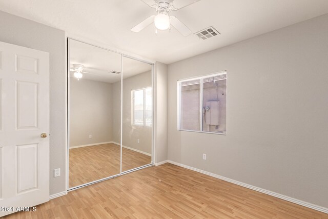 unfurnished bedroom with a closet, ceiling fan, and hardwood / wood-style flooring