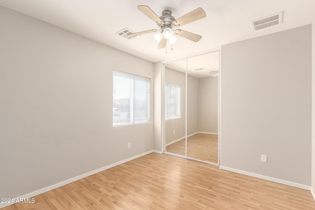 unfurnished bedroom with a closet, light wood-type flooring, and ceiling fan