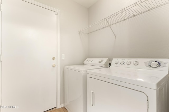 laundry room with separate washer and dryer and light wood-type flooring