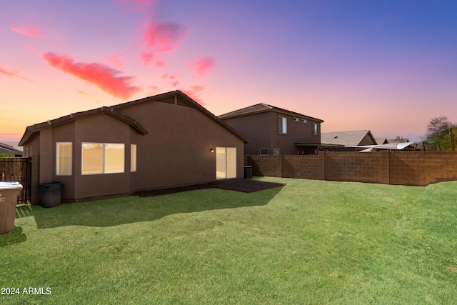 back house at dusk with a yard