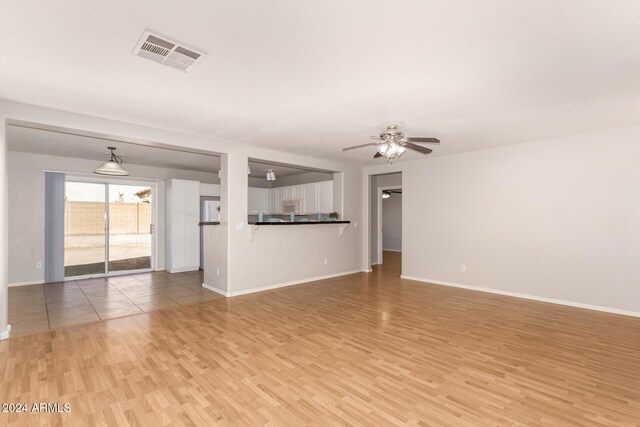 unfurnished living room with light wood-type flooring and ceiling fan