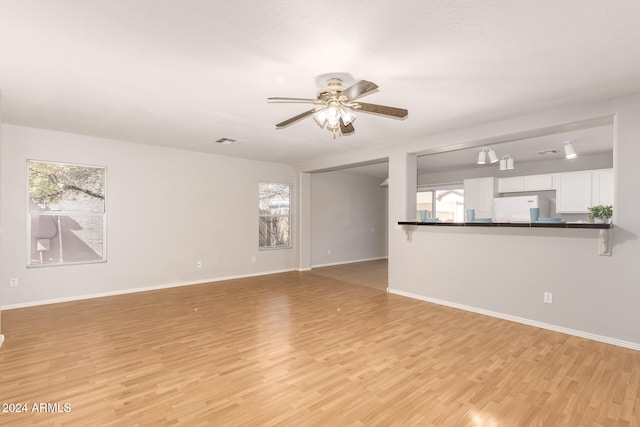 unfurnished living room featuring a healthy amount of sunlight, light wood-type flooring, and ceiling fan