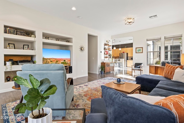 living room featuring hardwood / wood-style flooring and built in features