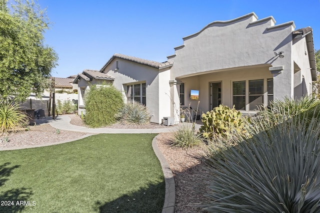 rear view of property with a lawn