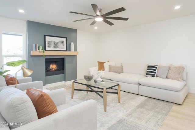 living room with light hardwood / wood-style flooring and ceiling fan