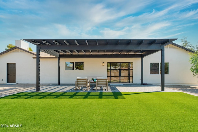 rear view of house with a lawn and a patio