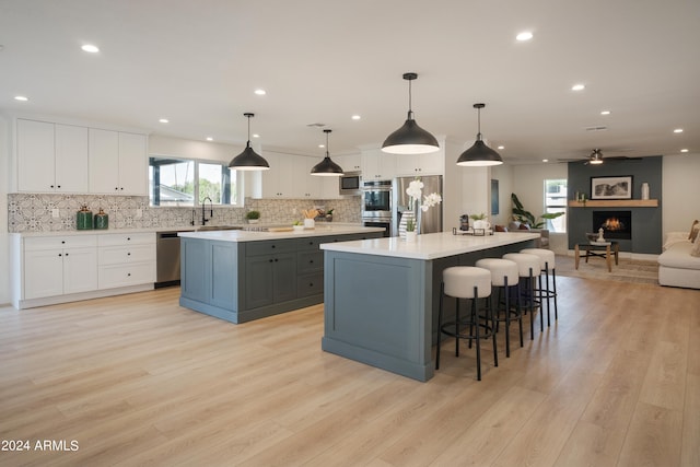 kitchen with a large fireplace, a large island, and white cabinetry