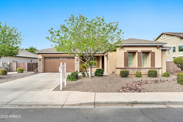 view of front of property with stucco siding, fence, concrete driveway, an attached garage, and a tiled roof