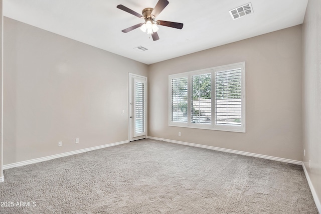 carpeted spare room featuring a ceiling fan, baseboards, and visible vents