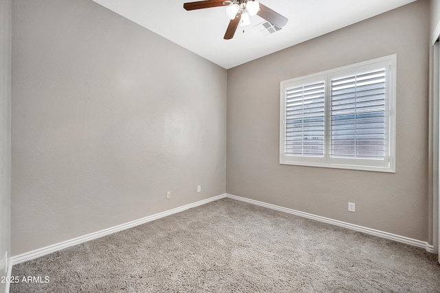 carpeted empty room featuring visible vents, baseboards, and ceiling fan