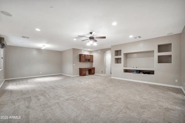 unfurnished living room featuring baseboards, arched walkways, visible vents, and ceiling fan