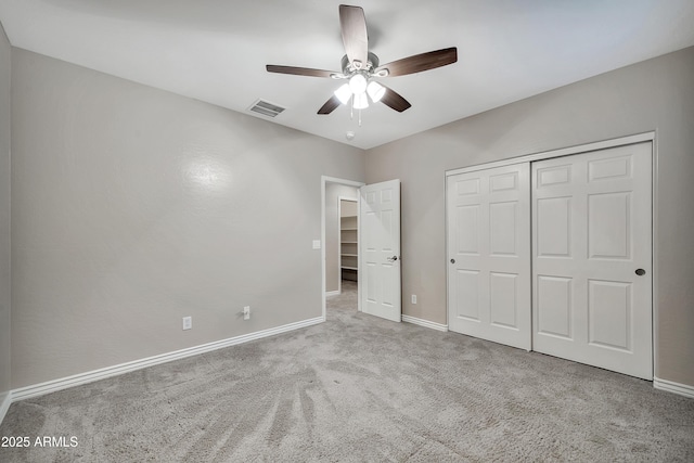 unfurnished bedroom featuring visible vents, baseboards, carpet flooring, a closet, and a ceiling fan