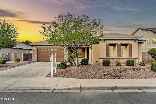 view of front of house featuring fence, an attached garage, stucco siding, concrete driveway, and a tile roof