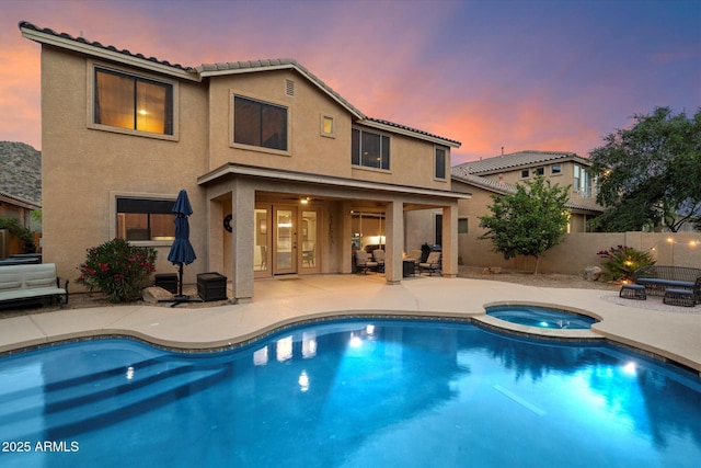 back of house featuring stucco siding, a tiled roof, fence, and a patio