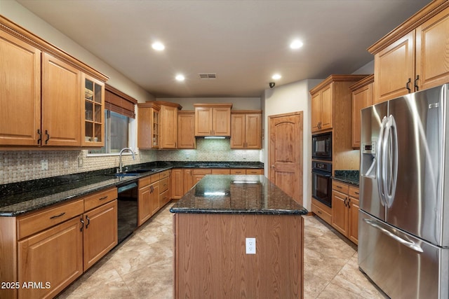 kitchen featuring a center island, a sink, visible vents, black appliances, and decorative backsplash