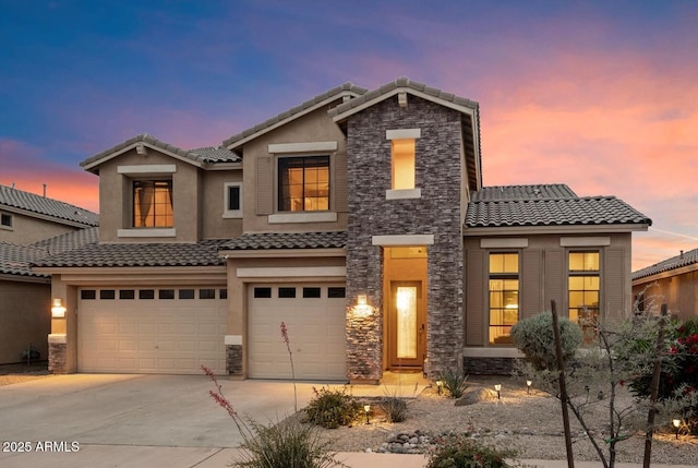 view of front of home featuring concrete driveway, stone siding, a tiled roof, and an attached garage
