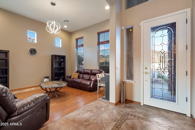 entrance foyer featuring baseboards, a chandelier, recessed lighting, and plenty of natural light