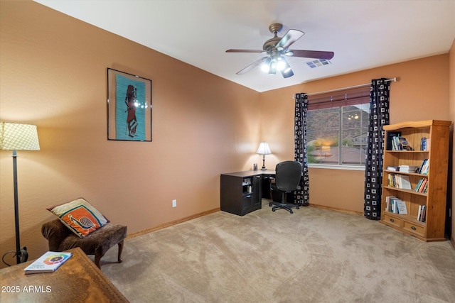 carpeted office space featuring baseboards, visible vents, and a ceiling fan