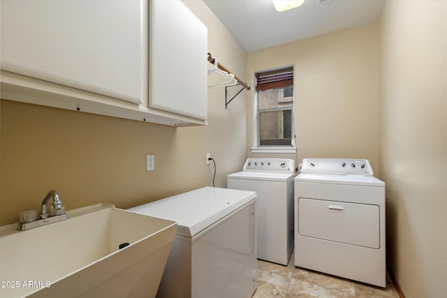 laundry room featuring separate washer and dryer, cabinet space, and a sink