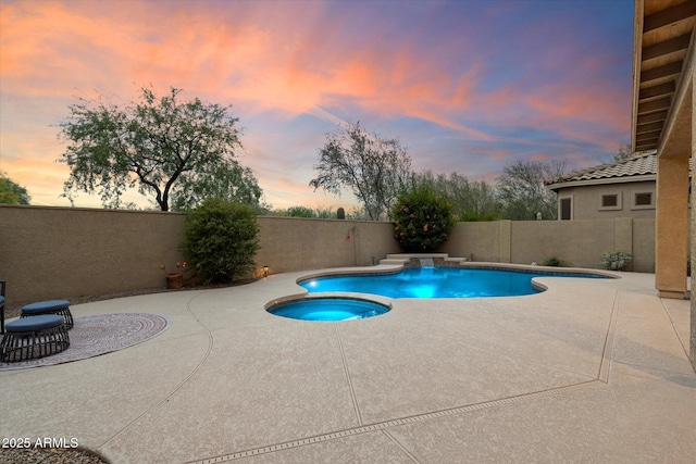 pool at dusk with a patio, an in ground hot tub, a fenced in pool, and a fenced backyard