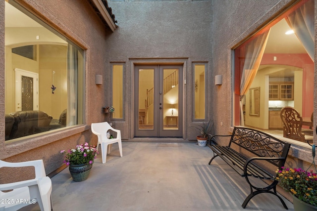 entrance to property with stucco siding and french doors