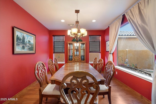 dining room featuring a chandelier, baseboards, a healthy amount of sunlight, and wood finished floors