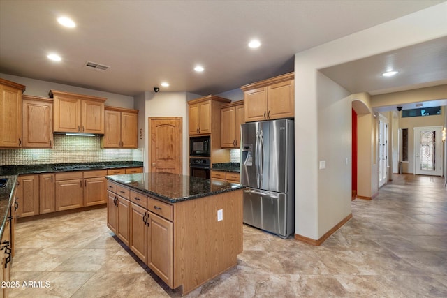 kitchen featuring visible vents, decorative backsplash, a kitchen island, arched walkways, and black appliances