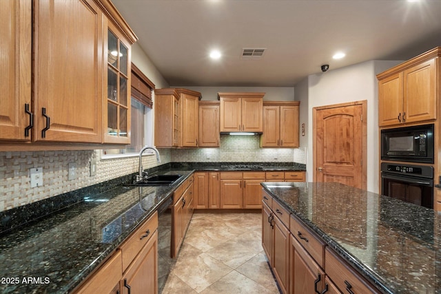 kitchen featuring visible vents, a sink, dark stone counters, black appliances, and tasteful backsplash