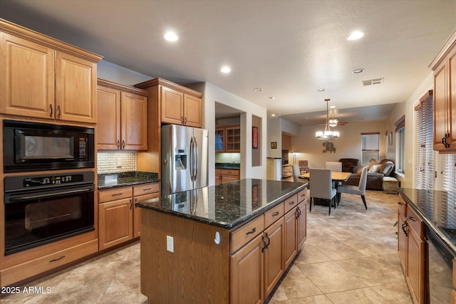 kitchen with visible vents, open floor plan, decorative backsplash, a kitchen island, and black appliances