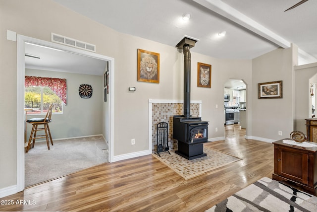 490 S Hideaway Dr, Dewey, AZ 86327 - living room with a wood stove, arched walkways, wood finished floors, baseboards, and beam ceiling