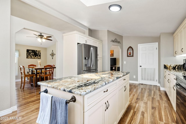 490 S Hideaway Dr, Dewey, AZ 86327 - kitchen featuring stainless steel appliances, light wood-style floors, light stone counters, and arched walkways