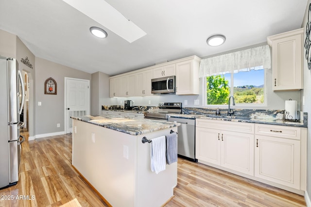490 S Hideaway Dr, Dewey, AZ 86327 - kitchen with stainless steel appliances, a center island, lofted ceiling, light wood-style floors, and dark stone counters