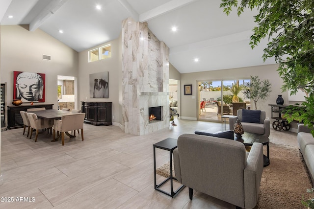 living room featuring beam ceiling, a fireplace, and high vaulted ceiling