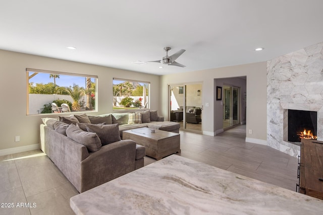 living room with ceiling fan and a fireplace