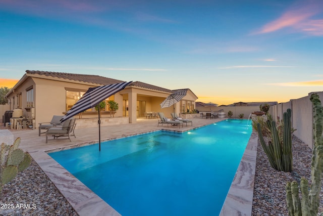 11934 S 181st Ave, Goodyear, AZ 85338 - pool at dusk featuring a fenced in pool, a patio area, and a fenced backyard