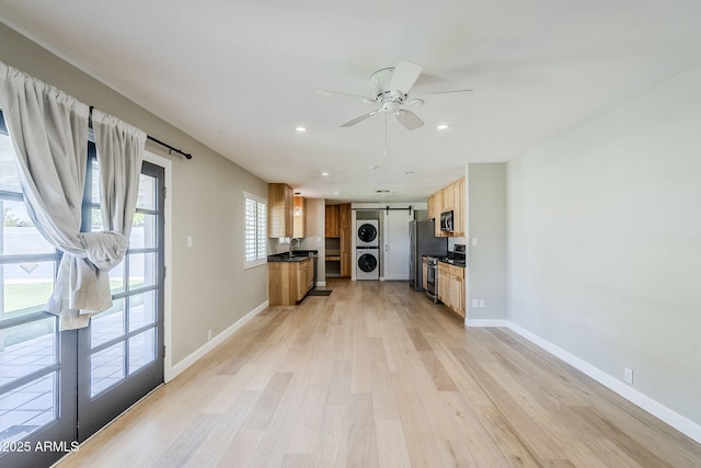 3138 N 82nd Pl, Scottsdale, AZ 85251 - kitchen with light wood-style floors, appliances with stainless steel finishes, stacked washing maching and dryer, and a barn door
