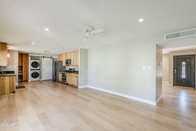 3138 N 82nd Pl, Scottsdale, AZ 85251 - kitchen featuring a barn door, stacked washer / dryer, visible vents, ceiling fan, and appliances with stainless steel finishes