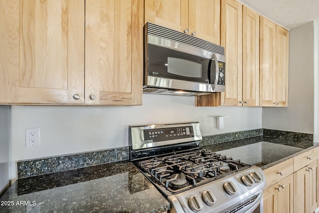 3138 N 82nd Pl, Scottsdale, AZ 85251 - kitchen featuring stainless steel appliances, light brown cabinets, a textured ceiling, and dark stone counters
