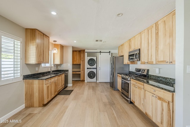 3138 N 82nd Pl, Scottsdale, AZ 85251 - kitchen with stacked washing maching and dryer, appliances with stainless steel finishes, light brown cabinetry, and a barn door