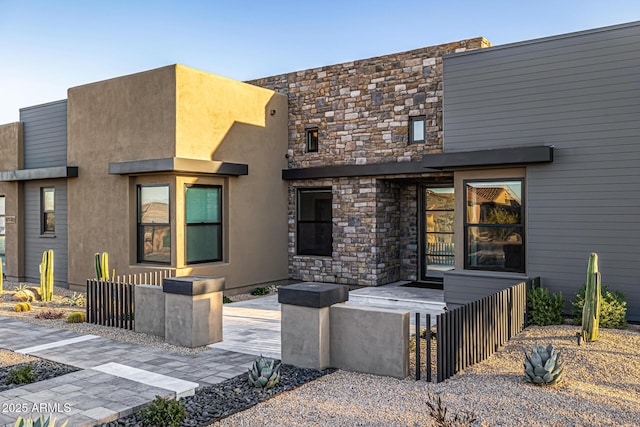 exterior space with stone siding and stucco siding