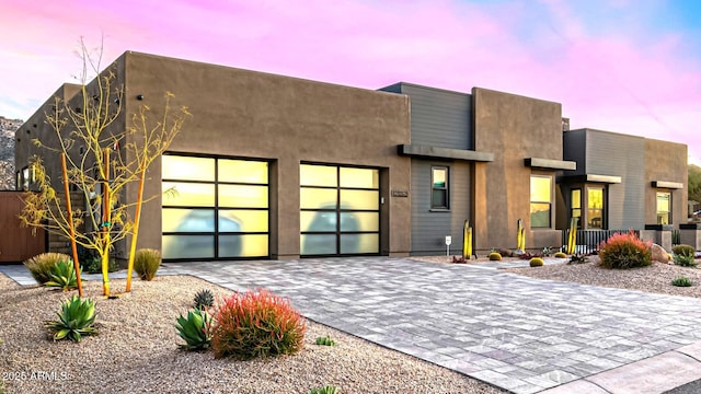 view of front of property with a garage and decorative driveway