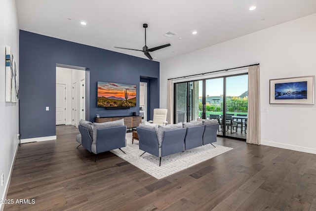 living area with dark wood-style floors, ceiling fan, visible vents, and baseboards