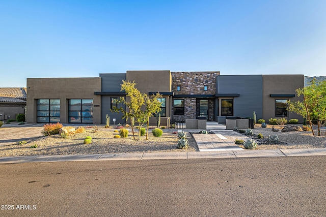 modern home featuring a garage, driveway, and stucco siding