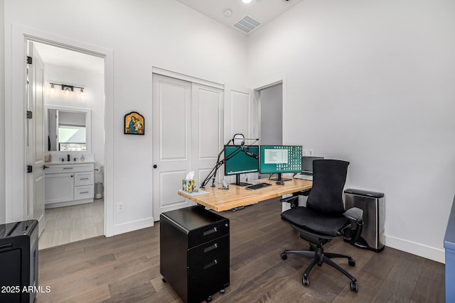 home office with dark wood-style floors, visible vents, and baseboards