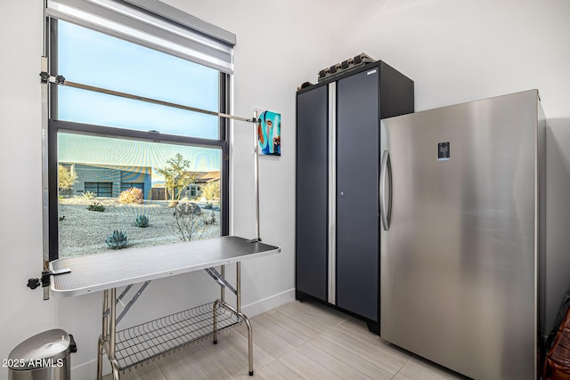 kitchen featuring freestanding refrigerator and baseboards